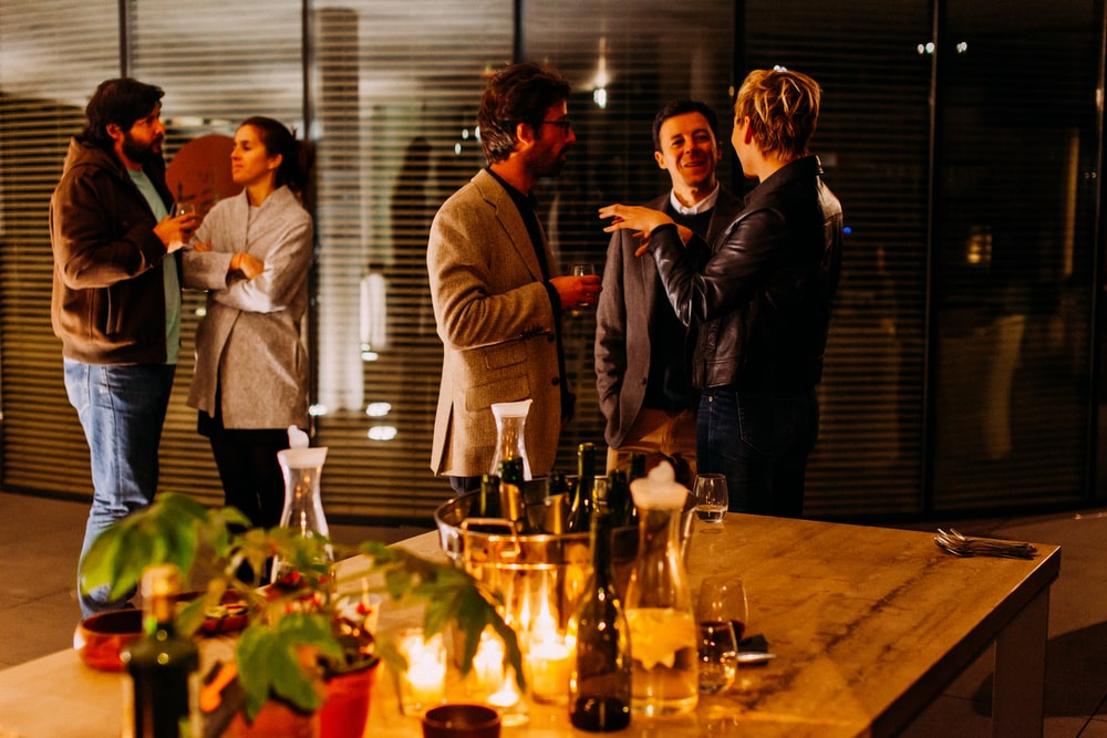 five person standing while talking each other